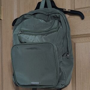 Army Green Backpack With Gray Interior And Silver Zippers.